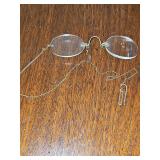 Unique antique rimless glasses by Stevens. Known as 'nose pinchers,' featuring a spring-loaded bridge that grips the nose instead of using ear arms. Gold color. No other markings found.