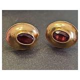 Women's gold tone post earrings with ruby color oval stone. Unmarked. Non-reactive to magnet.