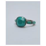 Coach ring featuring a faceted turquoise-colored stone in a silver-toned setting. Size 7