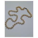 Vintage faux pearl necklace, similar to products manufactured in Japan during the 1950s. Pearls do not have ridges or dimples. Cannot definitely say they are faux or real. 12" long. Fish hook clasp.