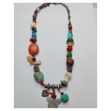 Colorful bohemian beaded necklace,e unique, handcrafted a mix of colorful beads, turquoise-colored stones, and charms like a butterfly and heart. Adjustable clasp.