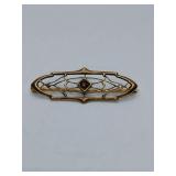 Antique 14K Art Deco style bar brooch featuring a gold-toned filigree frame adorned with tiny pearl and a central dark stone. There is HW stamped on clasp. Theses little pearl hooks where with the bro