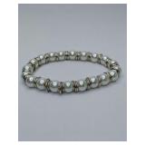 White cultured or high quality faux pearl stretch bracelet featuring silver-toned ring spacers between each pearl.