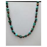 Chocker style necklace composed of irregular turquoise nuggets and faceted brown tiger
