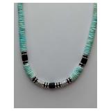 Turquoise-colored heishi beads paired with black and silver-toned accents, chocker style necklace.