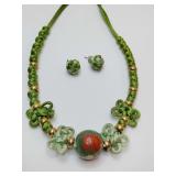 Green handmade jewelry set featuring a braided necklace with decorative knots and beads, accompanied by matching stud earrings. With gift bag.