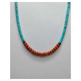 Necklace featuring orange coral and turquoise beads.