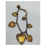 Vintage Victorian-style brass charm bracelet featuring embossed heart charms.