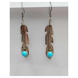 Handmade sterling silver feather dangle earrings featuring turquoise accents, commonly in the style of Native American Navajo artisan jewelry. Weigh 2 grams.