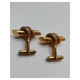vintage gold-toned cufflink featuring a classic baton design accented with a decorative braided knot. Germany is stamped on them.