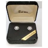 Vintage Tacoa Austrian crystal stud earrings featuring a floral design, blue crystals surrounding center clear crystal, in a display case.