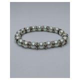 White cultured or high quality faux pearl stretch bracelet featuring silver-toned ring spacers between each pearl.