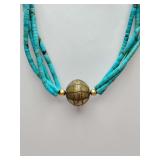 Multi-strand necklace made from turquoise heishi beads and brass accents.