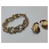 Set, Vintage Crown Trifari clip-on earrings abstract fan, shell, or ginkgo leaf design in a textured gold tone. And, Vintage 1950s Lisner Gold Tone Leaves & Floral Rhinestone Bracelet.