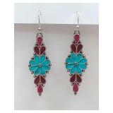 Dangle earrings featuring a central floral design with vibrant turquoise enamel petals. The backs are decorated as well.