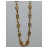 Vintage Trifari gold-tone filigree chain, characterized by its delicate, teardrop-shaped links with an openwork leaf design, 15" long.