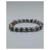 Grey cultured or high quality faux pearl stretch bracelet featuring silver-toned ring spacers between each pearl, these spacers are a squared material and have a more sterling appearance vs last three