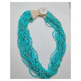 Multi-strand turquoise seed bead necklace, often designed in a southwest or bohemian style and secured with a button clasp.