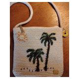 The Sak crochet crossbody bag featuring a beaded palm tree and sun design. Like New. 7 3/3" x 7 3/4", strap 21 1/2". Zipper closure.