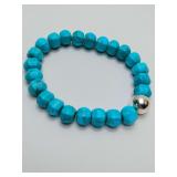 Turquoise beaded stretch bracelet, featuring a sterling silver accent bead.