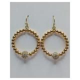 Gold-beaded hoop design with a striking, central crystal-pave ball accent. They are styled with a classic fishhook ear wire for a comfortable drop effect.