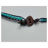 Beaded leather wrap necklace with turquoise-colored beads and a metal button closure.
