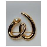 Vintage gold-tone modernist brooch featuring a stylized looped or squiggle design with a faux pearl accent. These types of statement brooches were popular in the 1980s.