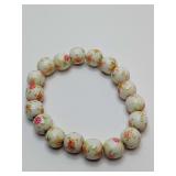 Sweet Porcelain bead stretchy bracelet featuring a white base with a pink and green floral pattern. With gift bag.