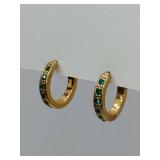 Vintage gold-tone huggie hoops from Avon featuring green rhinestones. Both original backs with Avon stamped on them.