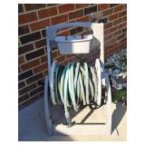 Garden hose reel and unknown amount of hose.