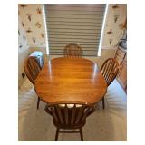 Oak pedestal table and four arrow back chairs. Table is 60 x 42 x 30 in tall including inserted 18-in leaf as shown. Chairs are 17.5 x 17.5 x 38.5 in tall. Seat height is 18 in.