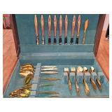 Gold flatware in cabinet. Pieces include: 8 dinner knives, 7 salad forks, 6 dinner forks, 8 soup spoons, 8 dessert spoons, 8 coffee spoons, and serving pieces. See all photos.