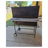 Heavy steel charcoal grill. 38x20.5 x 49 in tall not including smokestack or grill handles.