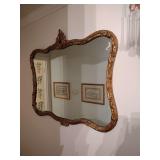 Ornate and decoratively framed gilt gold mirror