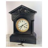 Antique Hamilton French black slate mantel clock in a Neoclassical style featuring a pitched pediment, full columns, and a white dial with Roman numerals