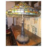 Tiffany style Dragonfly stained glass table lamp with a multicolor leaded glass shade and decorative metal base.