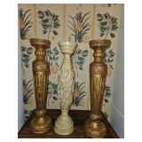3 candle holders with various designs. 1 Cream-colored pedestal candle holder with intricate floral carvings and a distressed, washed finish. 2 Matching gold toned. (1 has damage)
