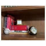 Group of books and fold up clocks. Vintage Linden folding travel clock-Panasonic Midwest group, Phinney- Walker fold up clock from Germany.