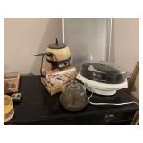 Miscellaneous kitchen wear. The new cookie sheet is 18“ x 26“, there’s a Oster vintage electric fondue pot, rice, and steamer bowl, covered cheese plate and a pasta maker