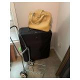 Black suitcase, rolling cart, and vintage escort bag
