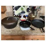 Two cast-iron skillets with a cast-iron Dutch oven