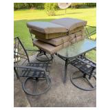 Glass top patio table set with four brown cushions. The table is 40 in.² the chairs are swivel the 23” x 20” x 35” with the seat height 16 inches before cushion. Needs cleaning