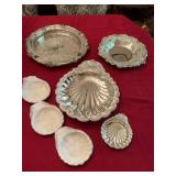 Group of silver dining serving pieces the back left does appear to be over cast iron and is peeling. The shell has four serving bowls with it.