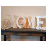 HOME letters, rustic white wood wreath "Home Sweet Home" script lettering, child angel figurine metal gate wings, vintage-style aluminum coat and hat hook mounted on a wooden base.
