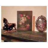 Chalkware western horse figurine, decorative floral still life oil painting, ornate metal oval wall picture frame under convex bubble glass.