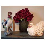 17-inch ceramic rooster Majolica style, red comb, blue tail feathers. Red hydrangea bouquet in dark green, woven basket-style vase. Large ceramic chicken.