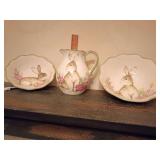 Maxcera set of three ceramic spring-themed serveware pieces watercolor-style rabbit, pink and yellow floral accents and scalloped, light green-trimmed edges.