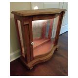 Vintage illuminated oak wood curio cabinet, tabletop or low-profile, serpentine bow-front design, curved glass, side windows, interior mirror back.