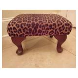 Traditional rectangular leopard print footstool/ottoman. Plush, padded top upholstered. Curved wooden cabriole style legs. 9.25"T x 14.5"L x 12.5"D.