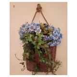 Super cute artificial blue hydrangea and greenery arrangement is presented in a woven rustic wicker welcome wall basket. Overall 30"L x 17"W.